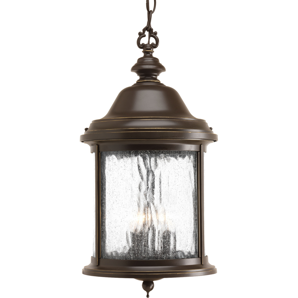 Inspired by lanterns from the Old World, the Ashmore collection incorporates handsome details, quill-scrolled arms and decorative finials. The water seeded glass is in a die-cast aluminum frame. The three-light hanging lantern. Antique Bronze finish.
